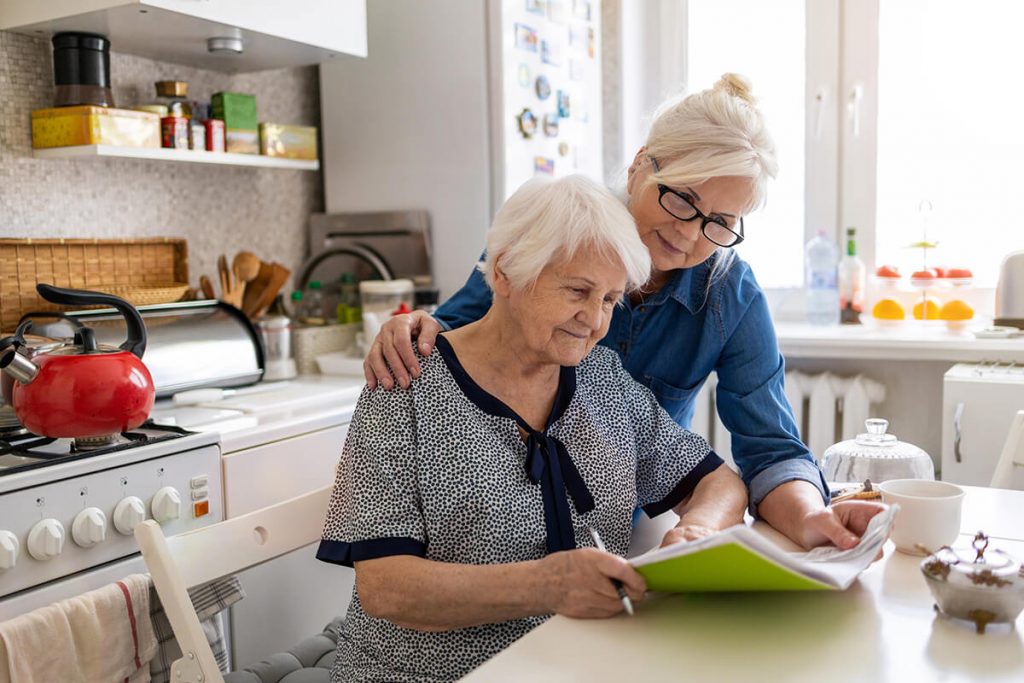 Mature woman helping elderly mother